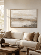 Neutral textured landscape wall art displayed above a cream living-room sofa