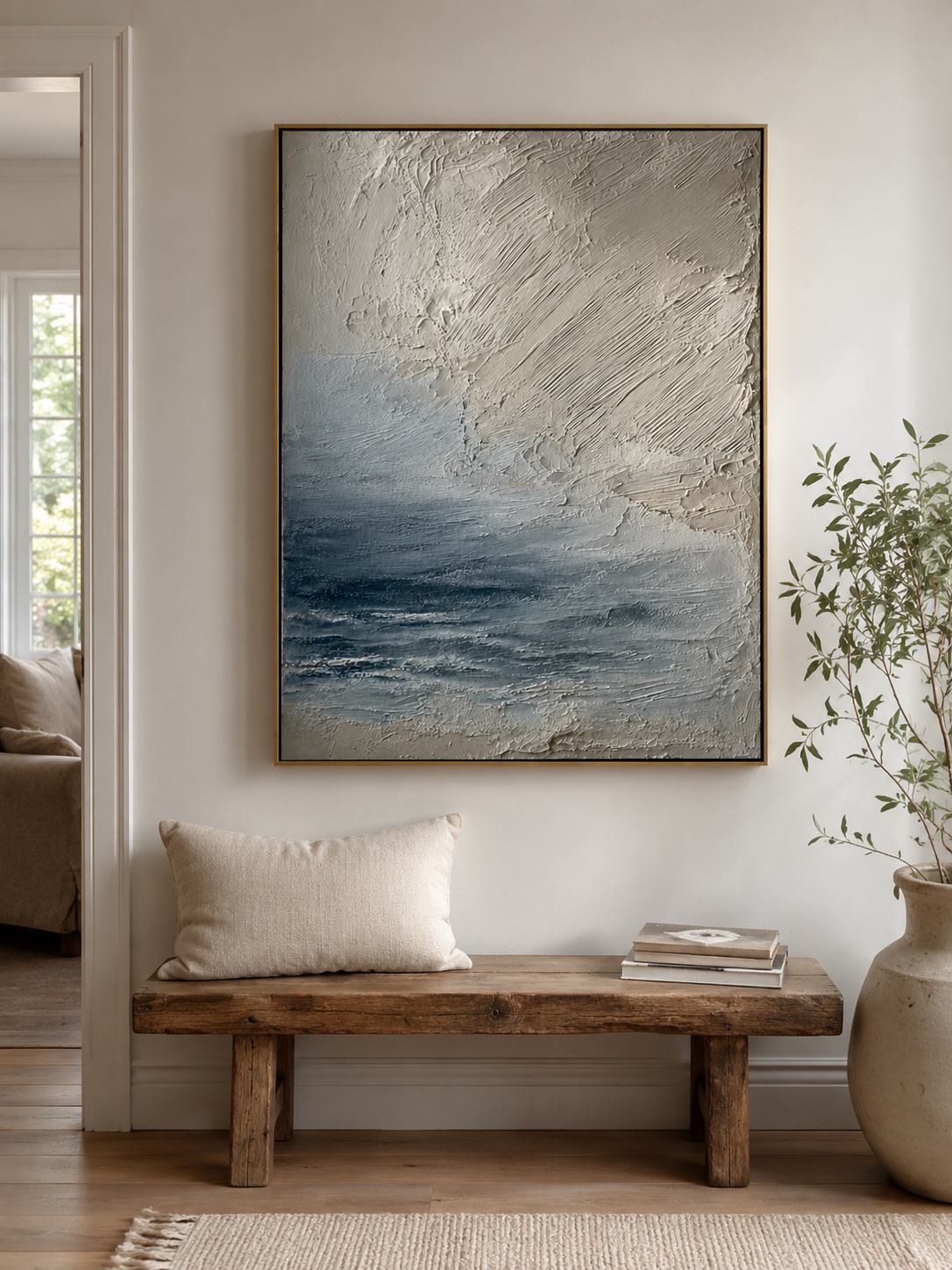 Vertical neutral seascape wall art displayed above a console table in a contemporary entryway