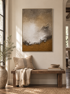 Vertical earth-tone shoreline wall art displayed above a console table in a contemporary entryway