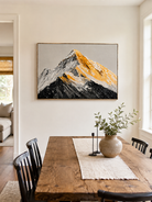 Textured black and gold mountain landscape displayed in a modern open-plan dining room