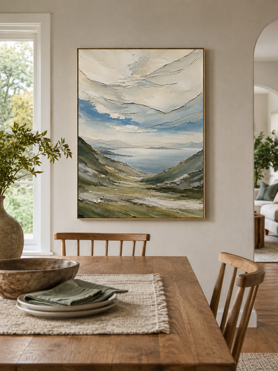 Impasto mountain lake painting displayed in a warm open-plan dining room
