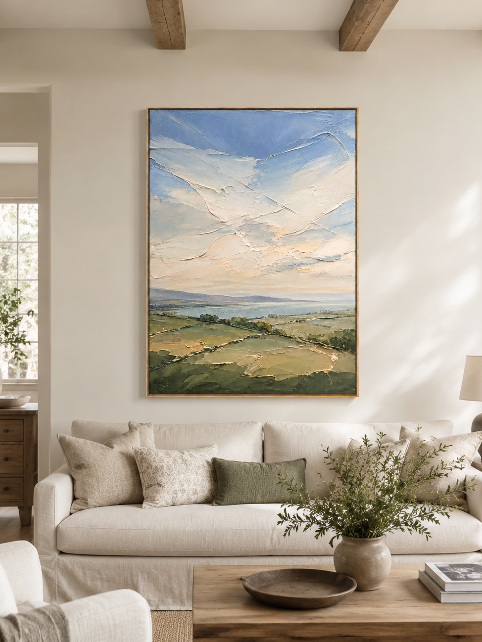 Sage green landscape painting above a cream sofa in an organic modern living room