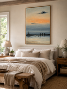Blue and peach coastal seascape wall art displayed above the bed in a calm neutral modern bedroom