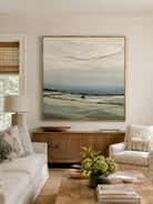 Sage green textured landscape painting by Evelyn Li displayed above a neutral sofa in an organic modern living room