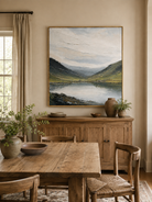 Hand-painted textured mountain landscape displayed in a modern open-plan dining room with natural wood furniture