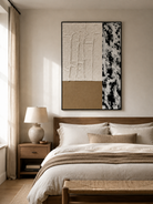 Black beige and white abstract wall art displayed above the bed in a calm neutral modern bedroom