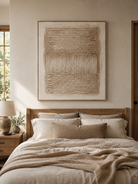 Ivory and beige textured wall art displayed above the bed in a calm minimalist bedroom