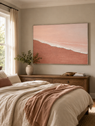 Pink beach and ocean wave painting displayed above the bed in a calm neutral modern bedroom