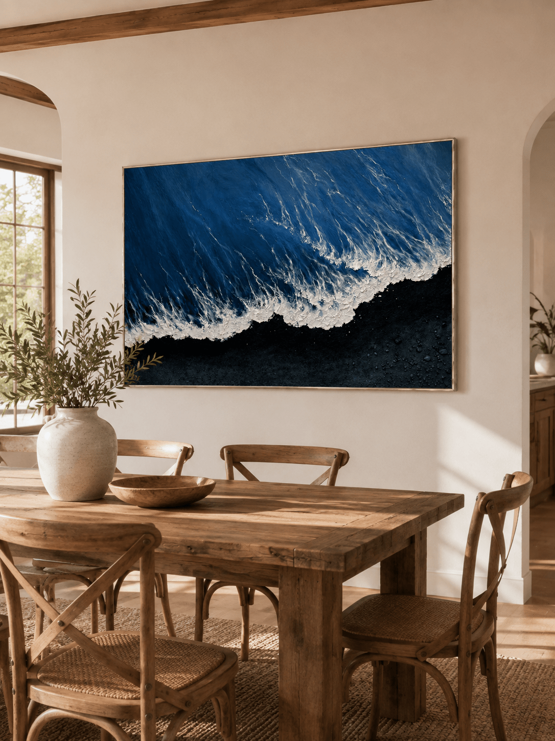 Hand-painted black sand coastal wall art displayed in an open-plan dining room with natural wood decor
