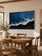 Hand-painted black sand coastal wall art displayed in an open-plan dining room with natural wood decor