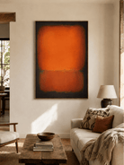 Burnt orange abstract painting displayed above a neutral sofa in a contemporary living room