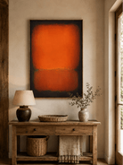 Vertical orange color field painting displayed above a console in a contemporary neutral entryway