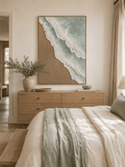 Textured sage green beach wall art displayed above the bed in a calm neutral bedroom