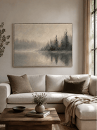 Neutral misty lake landscape painting displayed above a beige sofa in an organic modern living room