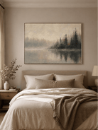 Foggy forest lake wall art displayed above the bed in a calm neutral bedroom