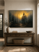 Horizontal golden pine forest painting displayed above a long wood console in a warm modern entryway