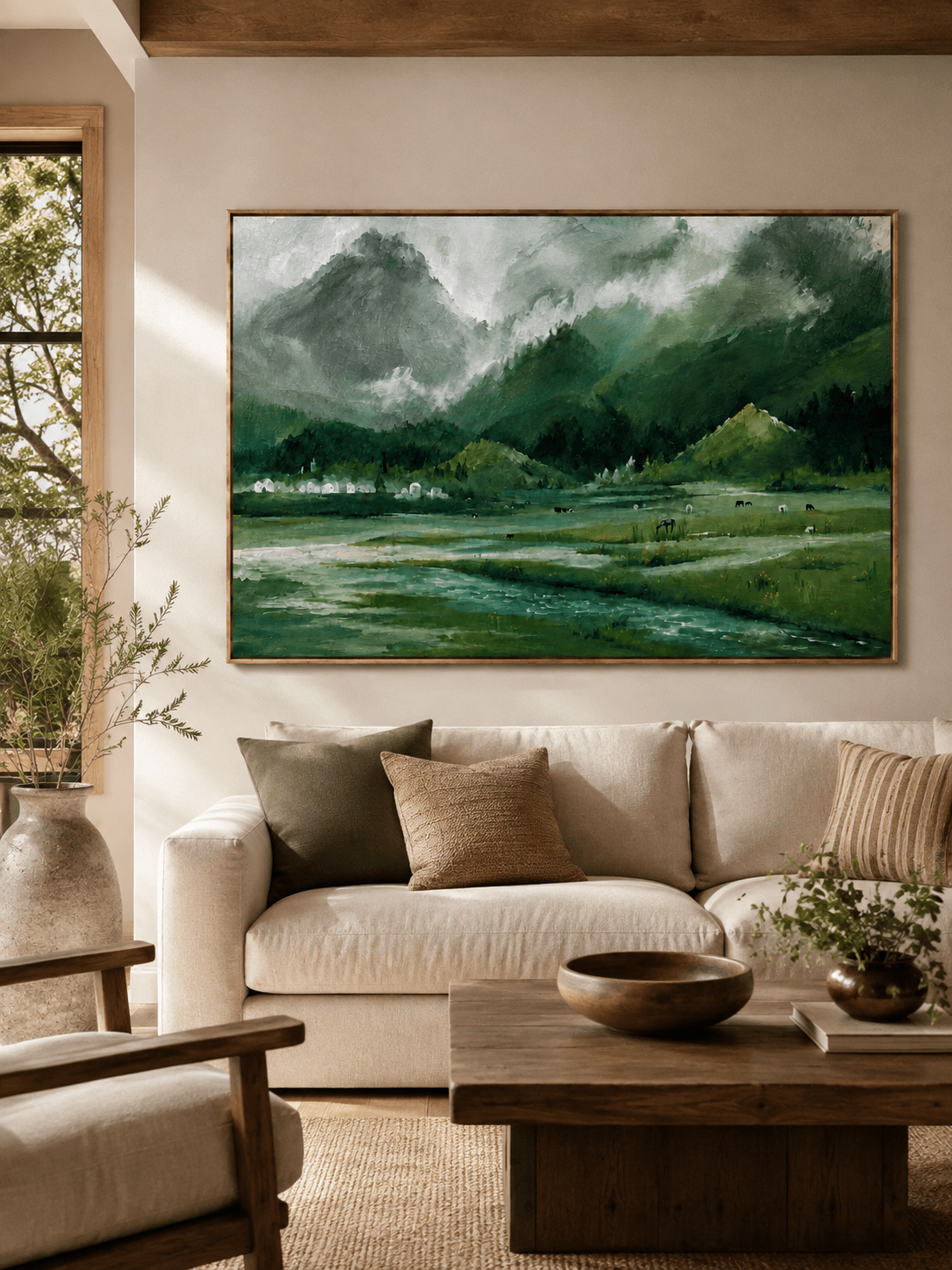 Green alpine mountain landscape painting displayed above a neutral sofa in an organic modern living room