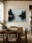 Hand-painted lake reflection landscape displayed in a dining room with natural wood furniture