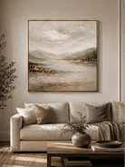 Large neutral textured mountain lake wall art displayed above a beige sofa in a modern living room