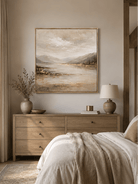 Neutral hand-painted mountain landscape wall art displayed above the bed in a warm modern bedroom