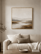 Large neutral textured mountain landscape wall art displayed above a beige sofa in a modern living room