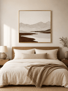 Minimalist textured mountain landscape painting displayed above the bed in a warm neutral bedroom