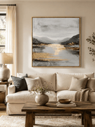 Large gray and gold mountain landscape wall art displayed above a beige sofa in a modern living room