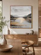 Large textured mountain landscape wall art in gray and gold displayed in a modern open dining room