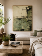 Sage green abstract wall art displayed above a neutral sofa in an organic modern living room