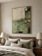 Green and ivory abstract painting displayed above the bed in a calm contemporary bedroom