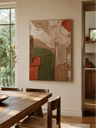Olive green and terracotta geometric wall art displayed in a modern open-plan dining room