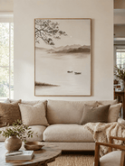 Japandi misty lake landscape painting above a neutral sofa in a serene modern living room