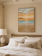 Aqua and peach seascape painting displayed above a bed in a calm coastal bedroom