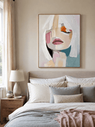 Textured woman portrait wall art displayed above a bed in a warm contemporary bedroom