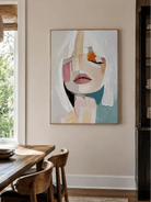 Modern abstract female portrait painting displayed in a neutral open-plan dining room