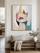 Textured feminine wall art above an entryway console in a contemporary neutral foyer