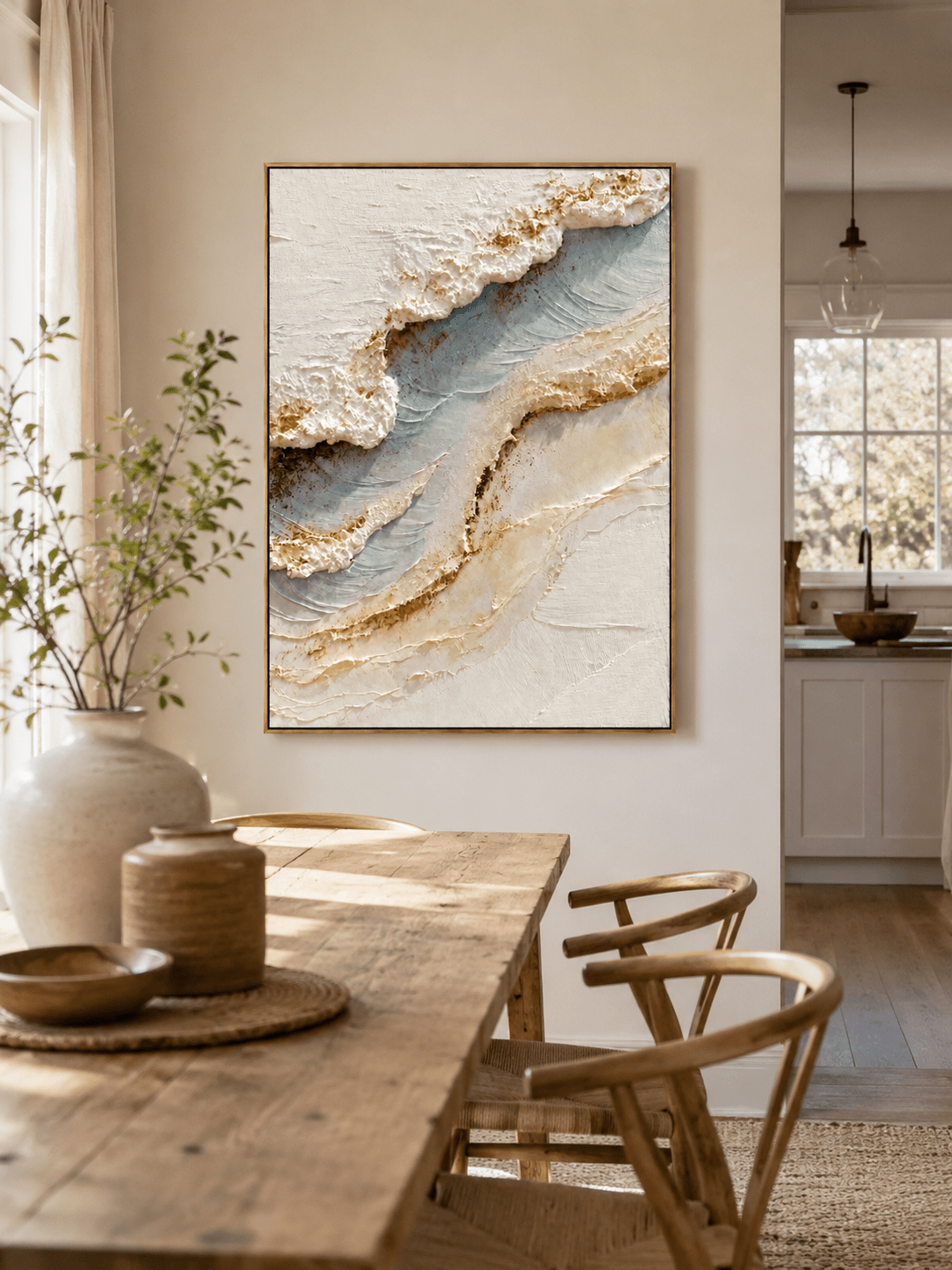 Neutral ocean wall art above an entryway console in an organic modern foyer