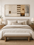 Wide beige gray and rust wabi-sabi abstract painting displayed above the bed in a warm neutral bedroom
