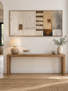 Extra wide neutral textured wall art displayed above a long entryway console in an organic modern interior