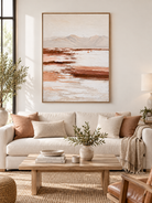 Large vertical terracotta mountain wall art displayed in a warm neutral organic modern living room