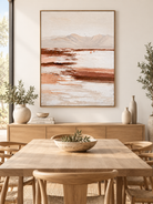 Vertical neutral mountain landscape wall art displayed in an open dining room with walnut and stone furniture