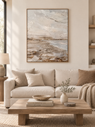 Large vertical neutral textured coastal wall art displayed in an organic modern cream living room