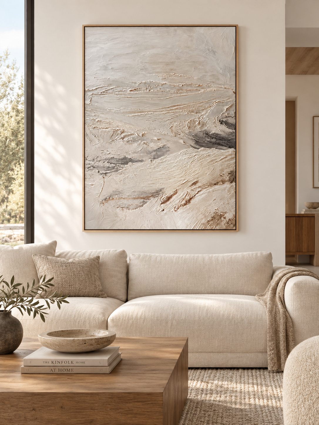 Large neutral textured abstract landscape painting displayed above a modern living room sofa in a minimalist interior