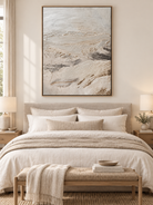 Neutral beige textured landscape painting displayed above a bed in a warm minimalist modern bedroom