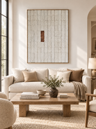 Large neutral textured geometric wall art displayed above a sofa in a minimalist modern living room