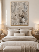 Neutral botanical vase painting displayed above a bed in a calming Japandi style bedroom