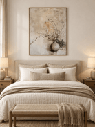Minimalist beige floral vase painting displayed above a bed in a calming Japandi style bedroom