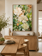 Large botanical floral wall art with ivory flowers and green leaves displayed in an open dining room