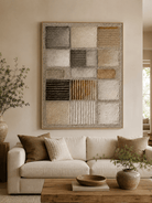 Large neutral textured geometric wall art displayed above a beige sofa in an organic modern living room
