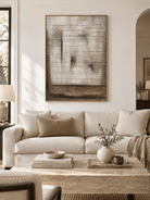 Large neutral textured grid wall art displayed above a sofa in a contemporary warm gray living room